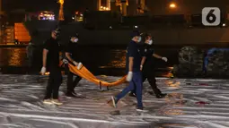 Tim DVI Polri membawa kantong jenazah yang diduga berisi bagian tubuh penumpang pesawat Sriwijaya Air SJ 182 di Dermaga JICT 2, Jakarta, Minggu (10/1/2021) dini hari. Sriwijaya Air SJ 182 hilang kontak dalam penerbangan dari Jakarta menuju Pontianak. (Liputan6.com/Helmi Fithriansyah)
