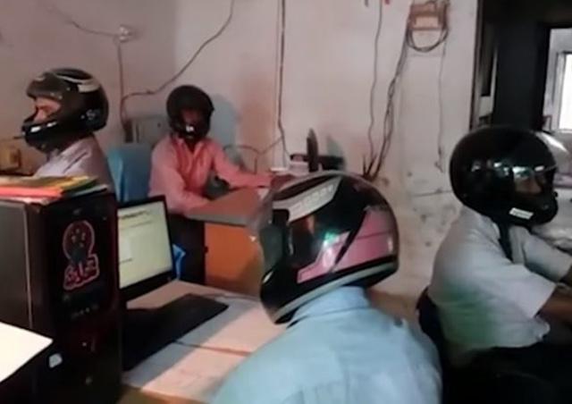 Para karyawan memakai helm saat kerja di ruang kerja mereka/copyright odditycentral.com