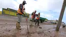 Petugas membersihkan lumpur di sepanjang jalan Grantham, Fiji, Senin (22/2). Fiji mulai melakukan bersih-bersih setelah badai Winston memporak-prandakan negara kepulauan tersebut hingga menewaskan sedikinya 10 orang. (REUTERS/Steven Saphore)