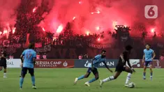 Suporter menyalakan flare saat menyaksikan laga Persija melawan Sabah FC pada laga uji coba internasional di Stadion Patriot Candrabhaga, Kota Bekasi, Minggu (5/6/2022). Pertandingan sepakbola kembali bisa disaksikan secara langsung setelah pemerintah melonggarkan aturan pemakaian masker di luar ruangan. (Liputan6.com/Helmi Fithriansyah)