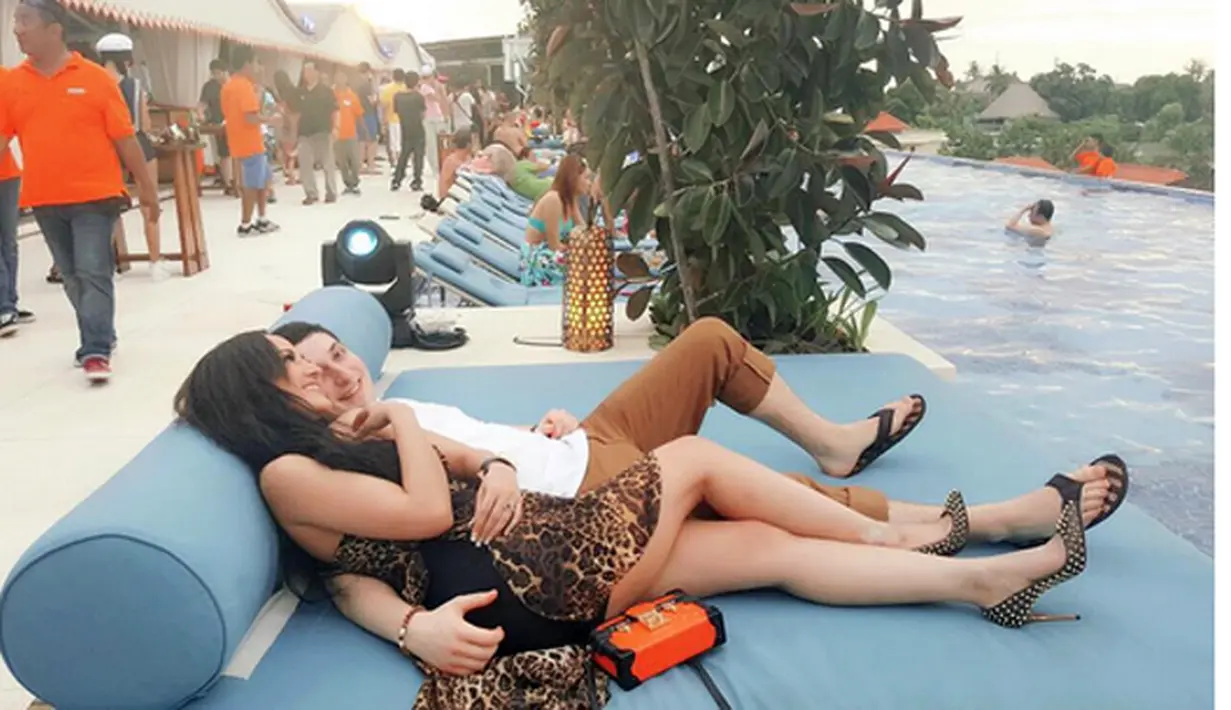 Cynthiara Alona dan pria bule sedang bersantai tiduran dipinggir kolam renang. (Instagram/@alonaqueen)