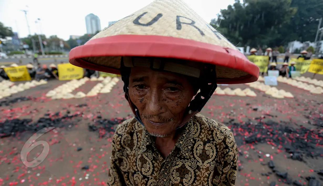 Warga Batang, Jawa Tengah mengenakan caping saat menggelar aksi di depan Istana Merdeka, Jakarta, Rabu (3/6/2015). Dalam aksinya mereka menuntut Presiden Jokowi menghentikan rencana pembangunan PLTU batubara di Batang. (Liputan6.com/Faizal Fanani)