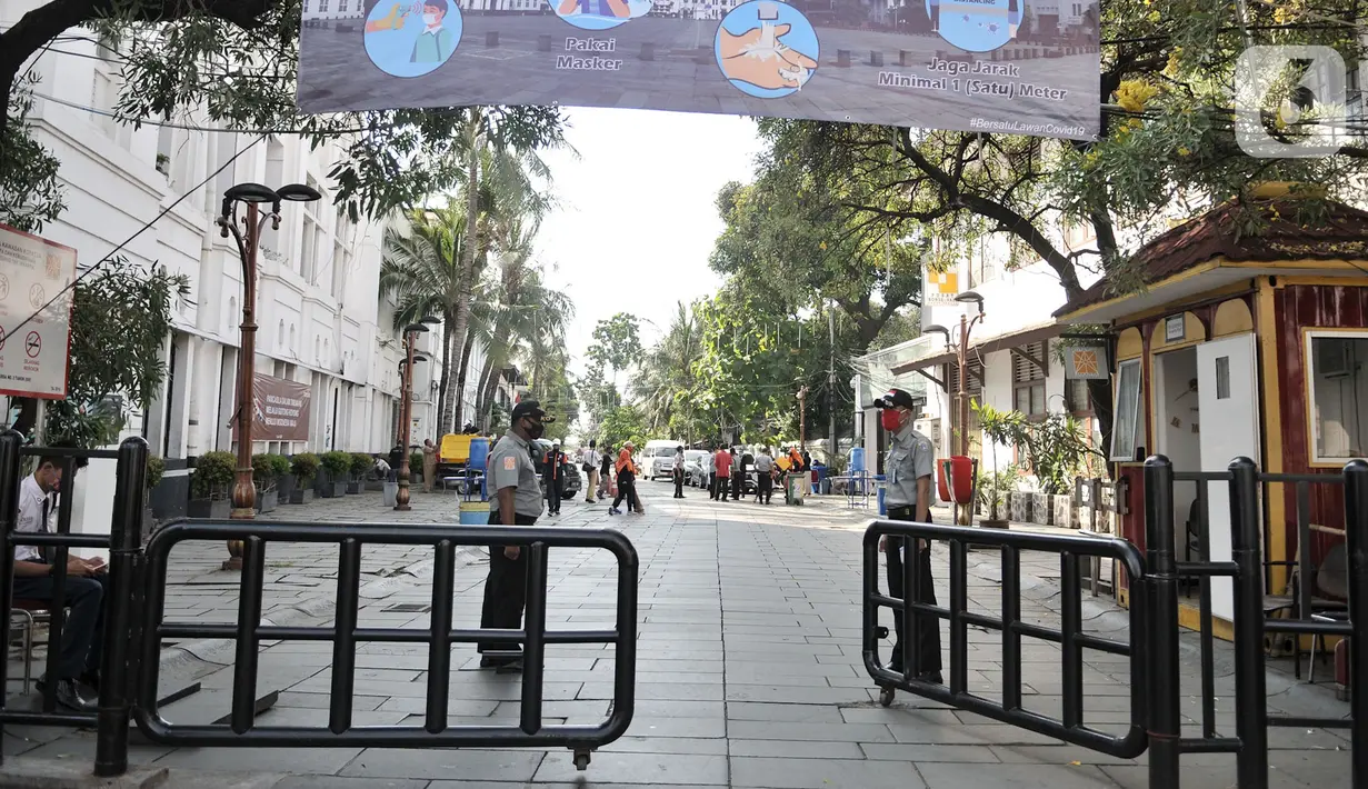 Petugas berjaga di kompleks wisata Kota Tua, Jakarta, Selasa (2/6/2020). Pengelola Kota Tua akan menerapkan pemeriksaan suhu tubuh, wajib masker, penggunaan face shield bagi pekerja restoran, penyediaan tempat cuci tangan, hingga penyemprotan cairan disinfektan. (merdeka.com/Iqbal S. Nugroho)