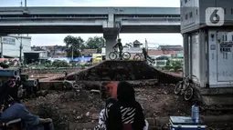 Para orangtua menemani anaknya bermain sepeda di Taman Pilar Jati, Cipinang Melayu, Jakarta, Kamis (5/11/2020). Para pecinta sepeda menyambut antusias setelah taman yang berada di kolong Tol Becakayu dan tepat di sebelah aliran Kalimalang itu dibuka untuk umum. (merdeka.com/Iqbal S Nugroho)