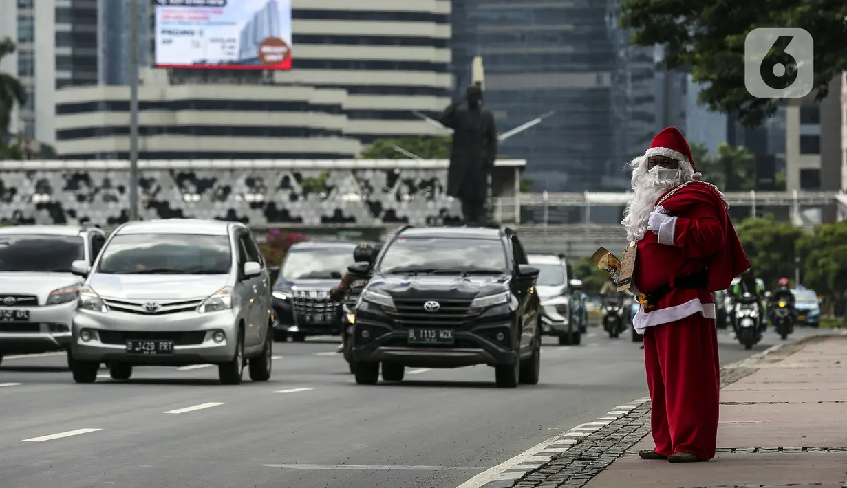 Pria berkostum Sinterklas saat membagikan kopi gratis kepada warga di kawasan Jalan Jenderal Sudirman, Jakarta, Sabtu (19/12/2020). Selain menyambut Natal, pembagian kopi tersebut juga untuk mempromosikan produk unggulan para petani dari berbagai daerah di Indonesia. (Liputan6.com/Johan Tallo)