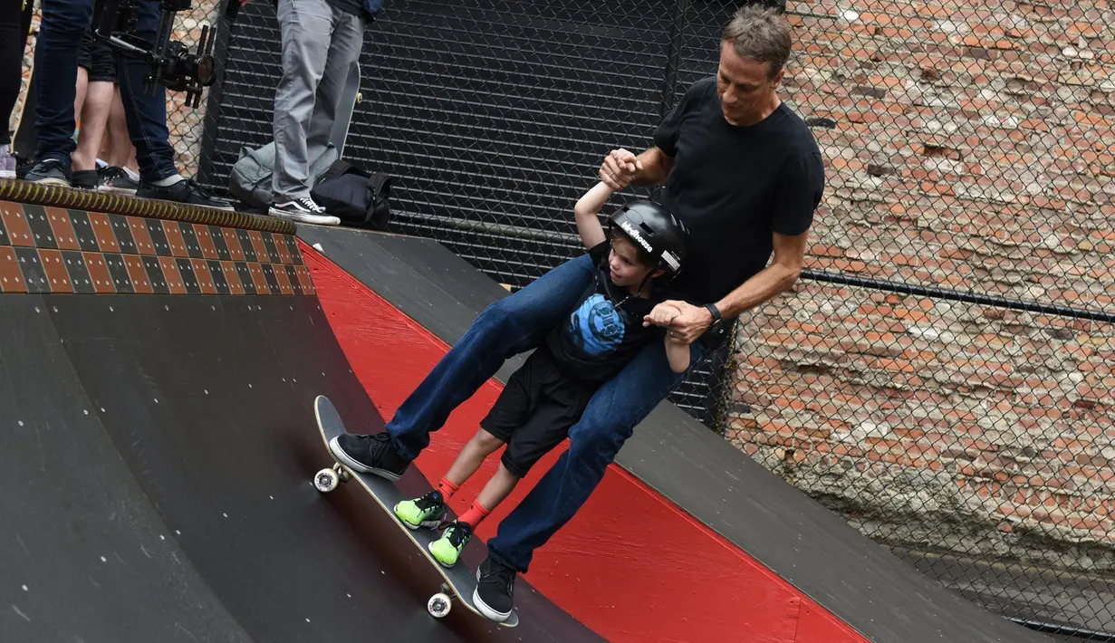 Legenda skateboard Tony Hawk bersama seorang anak Connor Curis meluncur dengan papan skateboard di Downtown Detroit (15/8). Taman skateboard ini  oleh Tony Hawk dan Ryan McGinness. (Tanya Moutzalias/Ann Arbor News-MLive.com Detroit via AP)