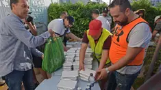 Relawan Tunisia membagikan makanan berbuka puasa gratis selama bulan suci Ramadan di Ariana dekat Tunis (7/5/2020). Masjid-masjid di Aljazair, Maroko dan Tunisia telah ditutup untuk membatasi penyebaran Covid-19, mencegah doa malam khusus. (AFP/Fethi Belad)