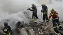 Petugas penyelamat dan pemadam kebakaran Ukraina membersihkan puing-puing di lokasi serangan rudal di Kharkiv pada 23 Januari 2024. (SERGEY BOBOK/AFP)