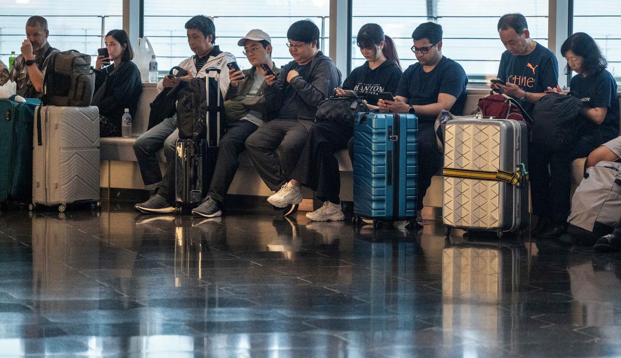 Penumpang menunggu di Terminal Internasional Bandara Haneda setelah penerbangan dibatalkan atau ditunda karena badai tropis Jangmi di Tokyo, Jepang, Rabu 3 Juni 2026. (Andrew CAALLERO-REYNOLDS/AFP)