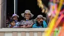 Orang-orang menyaksikan para peserta yang bergembira saat mengambil bagian dalam parade "Nyanyian untuk Bumi" selama Karnaval Kulit Hitam dan Kulit Putih di Pasto, Kolombia pada tanggal 3 Januari 2024. (JOAQUIN SARMIENTO/AFP)