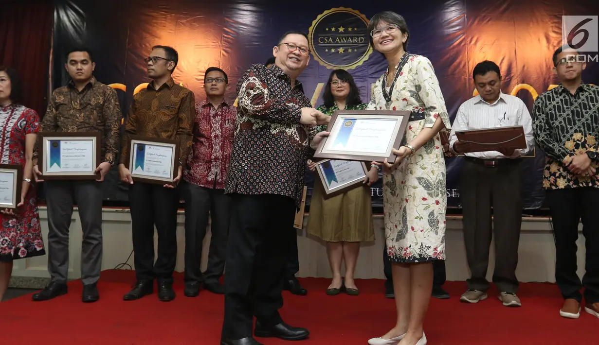 Ketua Umum PROPAMI (kiri) memberi piagam penghargan kepada Head of Protokol and Public Affairs Irnawati W Kahardja yang mewakili PT Surya Citra Media (SCM) Tbk dalam CSA Award 2019, Jakarta, Kamis (18/7/2019). SCM mendapat penghargaan CSA Award 2019 katagori growth stock. (Liputan6.com/Angga Yuniar)