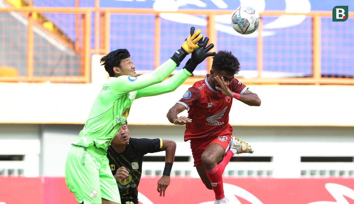 Pemain PSM Makassar, Yakob Sayuri (kanan) berduel udara dengan kiper Barito Putera, Muhammad Riyandi dalam laga pekan ke-5 BRI Liga 1 2021/2022 di Stadion Wibawa Mukti, Cikarang, Senin (27/9/2021). PSM kalah 0-2. (Bola.com/Ikhwan Yanuar)