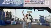Warga berswafoto di lintasan Formula E World Championship usai menyaksikan sesi Free Practice 1 (FP1) di Jakarta International E-Prix Circuit (JIEC) di Ancol, Jumat (20/6/2025). (Liputan6.com/Herman Zakharia)