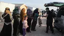 Pengungsi Suriah menerima kotak makanan yang didistribusikan organisasi amal lokal, sebelum berbuka puasa selama bulan suci Ramadhan di kamp pengungsi di pinggiran kota Dana yang dikuasai pemberontak, timur perbatasan Turki-Suriah di provinsi barat laut Idlib (3/4/2022). (AFP/Aaref Watad)