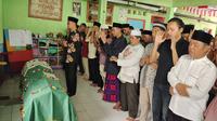 Wakil Wali Kota Depok, Imam Budi Hartono menyolati jenazah Muhammad Adnan Effendi korban tembok roboh MTs Negeri 19 Jakarta. (Liputan6.com/Dicky Agung Prihanto)