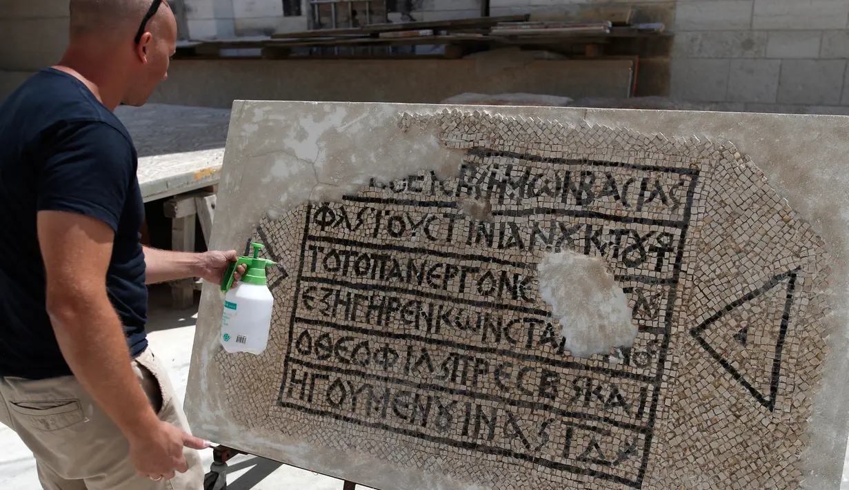 Seorang arkeolog meneliti lantai mosaik berusia 1.500 tahun di Museum Rockefeller, Yerusalem, Rabu (23/8). Prasasti tersebut menyebutkan nama Kaisar Romawi abad ke-6 Justinian dan juga Constantine. (AHMAD GHARABLI/AFP)