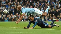 Pemain Manchester City, Vincent Kompany (atas), dan pemain Real Madrid, Casemiro, terjatuh saat berebut bola pada leg pertama semifinal Liga Champions di Stadion Etihad, Manchester, Rabu (27/4/2016) dini hari WIB. (AFP/Paul Ellis)