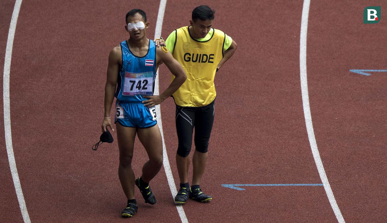 Peerapon Watbok asal Thailand melepas penutup matanya usai lomba para atletik nomor lari 400 meter putra klasifikasi T11 pada Asian Para Games 2018, di Stadion Utama Gelora Bung Karno Jakarta, Kamis(11/10/2018).  (Bola.com/Peksi Cahyo)