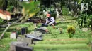 Petugas merawat makam di Tempat Pemakaman Umum (TPU) Karet Bivak, Jakarta, Selasa (11/5/2021). Pemprov DKI akan memberlakukan larangan ziarah kubur Idulfitri di seluruh TPU mulai 12 hingga 16 Mei untuk mencegah terjadinya penyebaran Covid-19 saat berkumpul untuk berziarah. (Liputan6.com/JohanTallo)