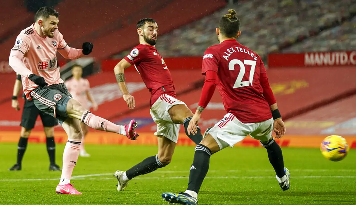Pemain Sheffield United Oliver Burke (kiri) mencetak gol ke gawang Manchester United pada pertandingan Liga Inggris di Old Trafford, Manchester, Inggris, Rabu (27/1/2021). Sheffield United menang 2-1. (AP Photo/Tim Keeton, Pool)