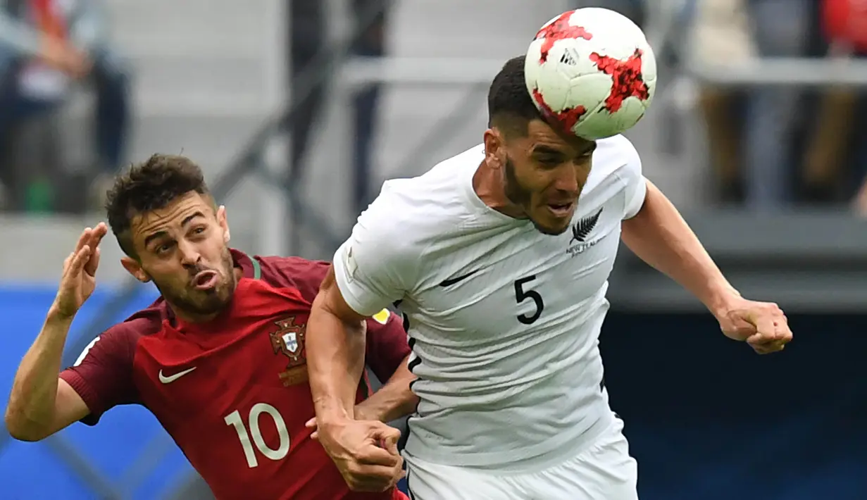 Bek Selandia Baru, Michael Boxall, duel udara dengan gelandang Portugal, Bernardo Silva. Portugal lolos sebagai juara Grup A dengan raihan tujuh poin atau unggul selisih gol atas Meksiko. (AFP/Kirill Kudryavtsev)