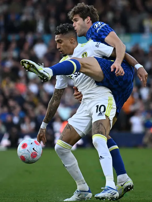 <p>Gelandang Leeds United Raphinha Dias Belloli (kiri) berebut bola dengan bek Chelsea Marcos Alonso (kanan) dalam laga tunda pekan ke-33 Liga Inggris 2021/2022 di Stadion Elland Road, Kamis (12/5/2022) dini hari WIB. Chelsea menang telak 3-0 atas Leeds United. (Oli SCARFF / AFP)</p>