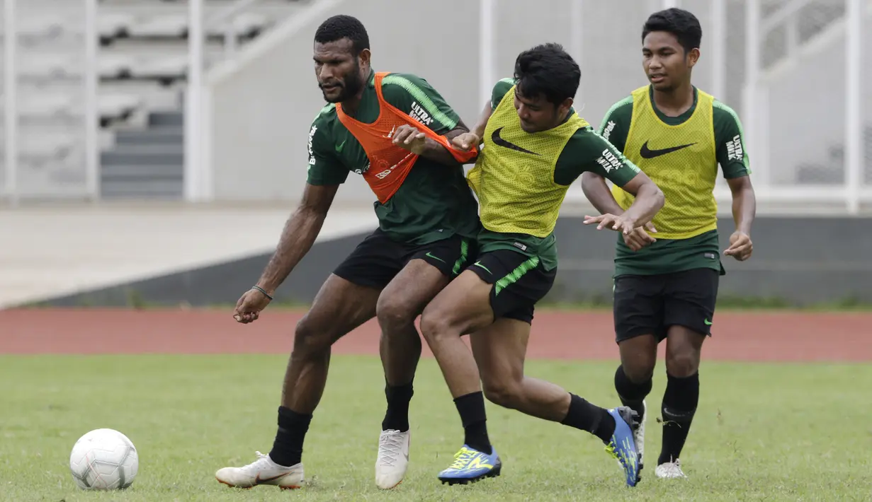 Pemain Timnas Indonesia U-22, Marinus Wanewar, berebut bola dengan Asnawi Mangkualam saat latihan di Stadion Madya, Jakarta, Jumat (18/1). Latihan ini merupakan persiapan jelang Piala AFF U-22. (Bola.com/Yoppy Renato)