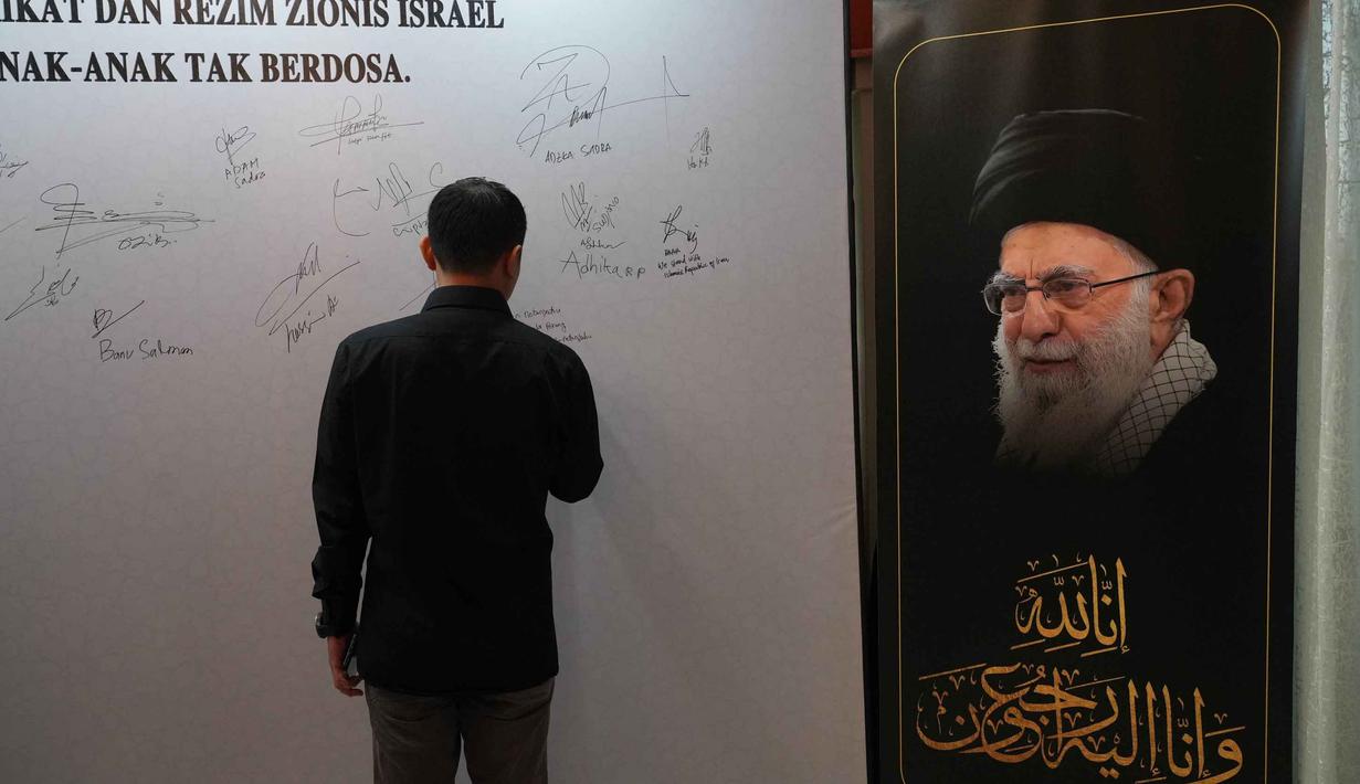 Dalam kegiatan tersebut, warga yang hadir turut menandatangani petisi sebagai bentuk solidaritas dan kepedulian terhadap para korban, termasuk pejabat dan masyarakat sipil Iran yang terdampak situasi konflik. Tampak dalam foto, seorang pria menandatangani dinding penghormatan sementara untuk mendiang Pemimpin Tertinggi Iran Ayatollah Ali Khamenei di kediaman duta besar Iran untuk Indonesia, Jakarta, Kamis 5 Maret 2026. (AP Photo/Tatan Syuflana)