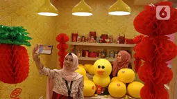 Pengunjung berswafoto di instalasi BT21 di Atrium Senayan City, Jakarta, Rabu (22/1/2020). Jelang Tahun Baru Imlek, Senayan City menghadirkan instalasi Mega Brown setinggi 2,5 meter dan Pop Up Shop terbesar yang bisa dinikmati mulai 17 Januari sampai 9 Februari 2020. (Liputan6.com/Herman Zakharia)