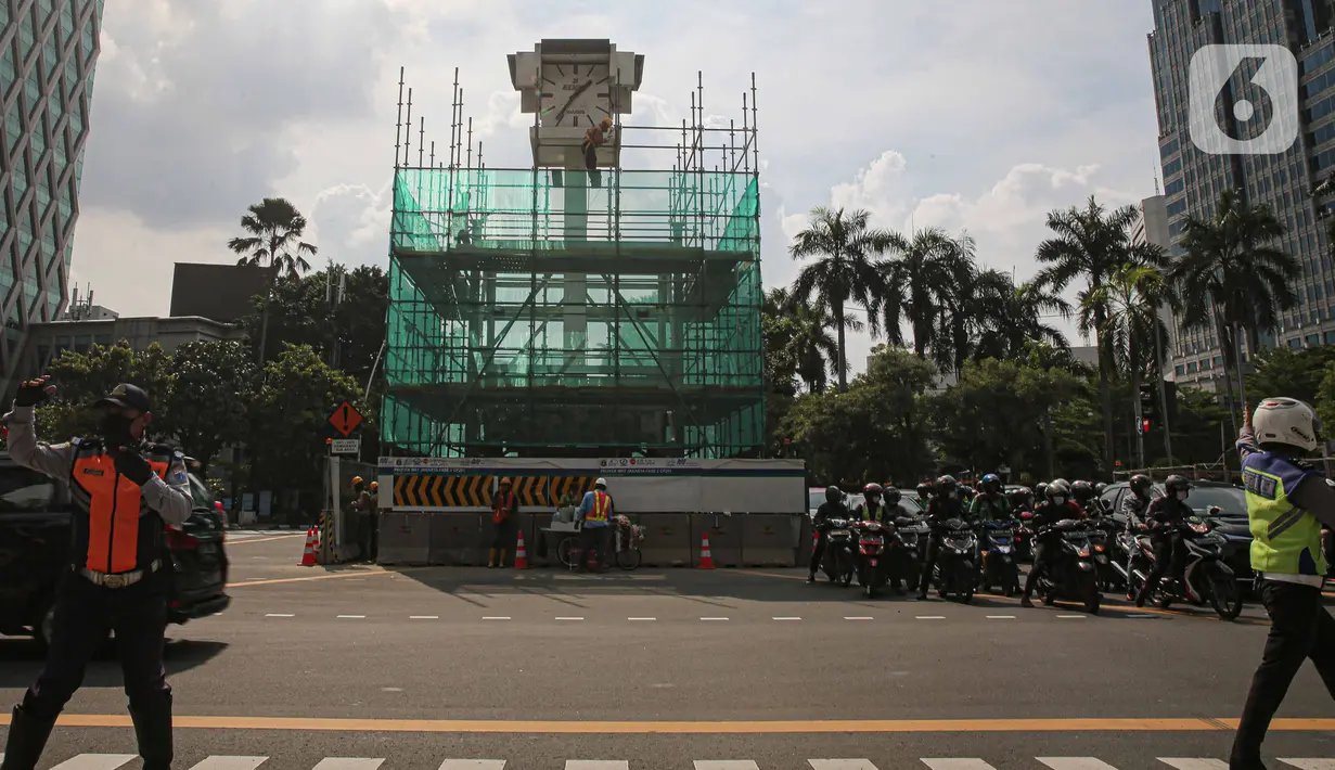 Pekerja memasang penutup di Tugu Jam Thamrin, Jakarta, Kamis (18/11/2021). PT MRT Jakarta (Perseroda) dalam waktu dekat akan memindahkan sementara Tugu Jam Thamrin di Jakarta Pusat yang merupakan bangunan cagar budaya. (Liputan6.com/Faizal Fanani)