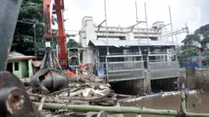 Petugas menggunakan alat berat saat mengangkut tumpukan sampah kiriman di Pintu Air Manggarai, Jakarta, Minggu (29/12/2019). Hujan deras yang mengguyur Jakarta dan sekitarnya sejak pagi hingga siang tadi menyebabkan penumpukan sampah di Pintu Air Manggarai. (merdeka.com/Iqbal Nugroho)