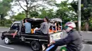 Meski hal itu disadari mengundang maut serta melanggar aturan lalu lintas, mereka tetap nekat berpergian menggunakan mobil bak terbuka, Jakarta, Kamis (31/7/14). (Liputan6.com/Faizal Fanani)