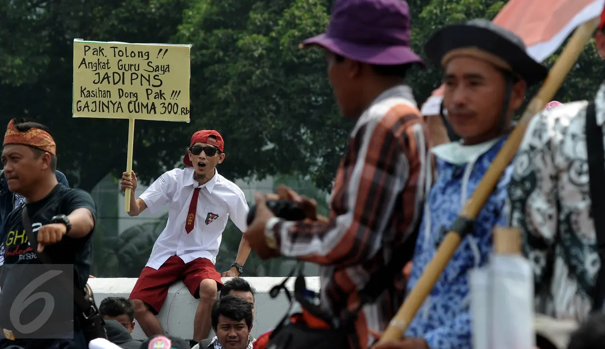 Pengunjuk rasa membawa karton bertuliskan tuntutan mereka saat menggelar aksi mogok dan unjuk rasa di depan gedung DPR/MPR, Jakarta, Selasa (15/9). Para guru honorer itu menuntut Pemerintah mengangkat mereka menjadi PNS. (Liputan6.com/Johan Tallo)