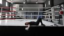 Seorang petinju amatir beristirahat setelah sesi latihan di All Stars Boxing Club, Kiev, Ukraina, 10 Mei 2022. Suara hip hop bercampur dengan bunyi pukulan tinju saat sekelompok petinju melepaskan stres terpendam di tengah perang Ukraina. (Sergei SUPINSKY/AFP)