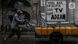 Penjual air melintasi di depan mural di kawasan Jakarta Pusat. Selasa (24/8/2021). Menjamurnya mural dan grafiti penuh muatan kritikan merupakan suara para seniman untuk berekspresi di tengah pandemi. (Liputan6.com/Johan Tallo)