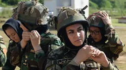 Kadet tentara wanita Afghanistan memakai helm sebelum mengikuti program latihan militer di Akademi Pelatihan Perwira di Chennai, India (12/12/2019). Sebanyak dua puluh kadet tentara Afghanistan mengikuti program latihan militer tersebut. (AFP/Arun Sankar)