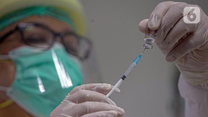 Vaksinator menyiapkan vaksin COVID-19 sebelum menyuntikkannya kepada Wakil Menteri Kesehatan Dante Saksono Harbuwono di RSCM, Jakarta, Kamis (14/1/2021). Menurut Menteri Kesehatan Budi Gunadi Sadikin, tahap awal program vaksinasi akan menyasar tenaga kesehatan. (Liputan6.com/Faizal Fanani)