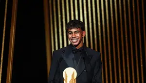 Penyerang muda Barcelona, Lamine Yamal, menerima Kopa Trophy, lambang pemenang predikat pemain muda terbaik di seremonial Ballon d'Or yang berlangsung di Theatre du Chatelet di Paris, Senin (28/10/2024) malam waktu setempat. (FRANCK FIFE / AFP)