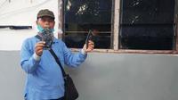 Seorang karyawan PT Langgam Harmuni memperlihatkan bukti penyerangan dan perusakan barak karyawan. (Liputan6.com/M Syukur)