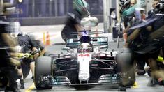 Pebalap Mercedes, Lewis Hamilton menanti perbaikan mobilnya oleh mekanik saat berada di pit lane pada sesi latihan bebas F1 GP Singapura, Marina Bay City Circuit, (15/9/2017). (AP/Wong Maye-E)