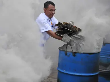 Petugas membakar Sisik Penyu kering saat pemusnahan barang bukti perdagangan ilegal satwa langka di Mabes Polri, Jakarta, Selasa (1/12). Barbuk yang dimusnahkan berupa 345 Kg Sisik Penyu kering dan 70 Kg daging Penyu kering. (Liputan6.com/Gempur M Surya)