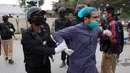 Polisi menangkap dokter saat aksi demonstrasi di Pakistan, Senin (6/4/2020). Kepolisian Pakistan mengatakan 30 orang diamankan karena dokter dan perawat tidak mengikuti larangan pertemuan publik saat lockdown diberlakukan untuk melawan penyebaran virus. (AP Photo/Arshad Butt)
