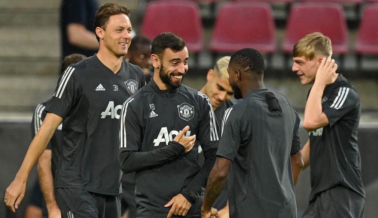 Pemain Manchester United, Bruno Fernandes bercanda dengan Aaron Wan-Bissaka saat sesi latihan jelang laga Liga Europa di Stadion Rhein Energie, Cologne, Minggu (9/8/2020). Manchester United akan berhadapan dengan Copenhagen. (AFP/Sascha Steinbach)