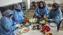 Para wanita membuat maftoul atau couscous di Khan Yunis, Jalur Gaza, Palestina, 10 Januari 2022. Secara tradisional, makanan ini dimasak menggunakan alat kukus. (SAID KHATIB/AFP)
