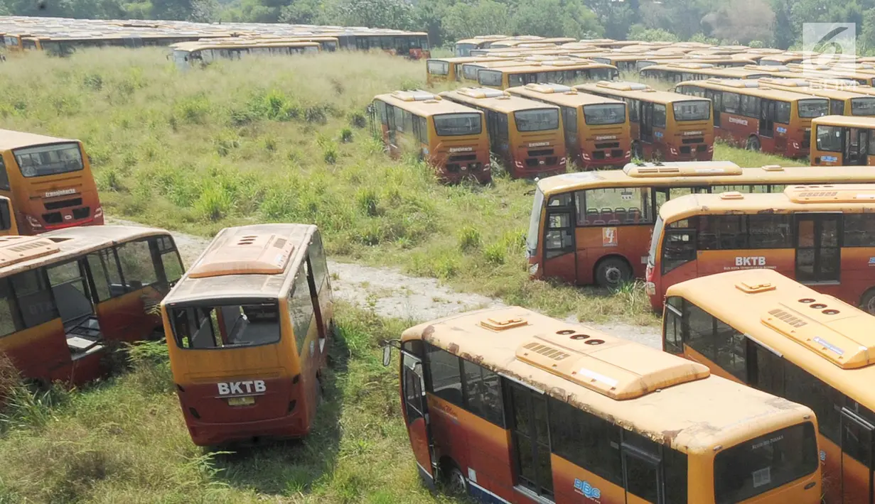 Deretan  bus Transjakarta yang sudah tidak digunakan lagi diparkir di lahan kosong di Dramaga, Kabupaten Bogor, Jawa Barat, Minggu (28/7/2019). Kurang lebih 300 bus Transjakarta dengan kondisi tak terawat diparkir di lahan kosong sejak 2018. (merdeka.com/Arie Basuki)