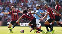 Striker Manchester City, Sergio Aguero, berusaha melewati pemain Bournemouth pada laga Premier League 2019 di Stadion Vitality, Minggu (25/8). Manchester City menang 3-1 atas Bournemouth. (AFP/Glyn Kirk)