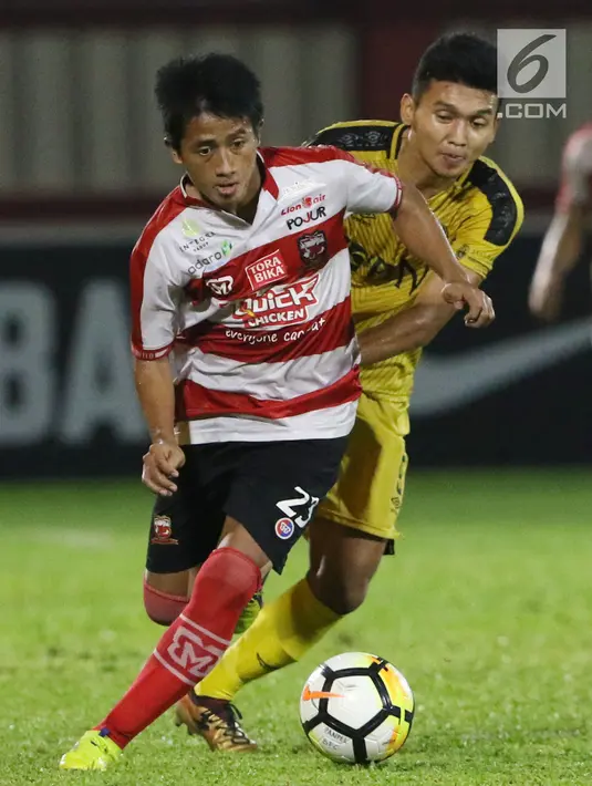 Pemain depan Madura United, Bayu Gatra (kiri) menghindari kawalan pemain Bhayangkara FC, Dendy Sulistyawan pada lanjutan Go-Jek Liga 1 Indonesia 2018 bersama Bukalapak di Stadion PTIK, Jakarta, Kamis (7/6). (Liputan6.com/Helmi Fithriansyah)