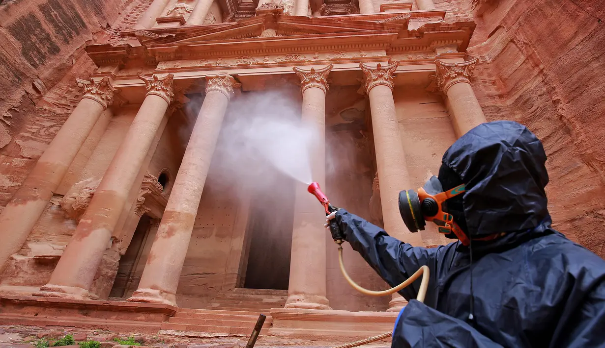 Petugas menyemprotkan cairan disinfektan di kota arkeologi Petra, Yordania, 17 Maret 2020. Berdasarkan data terbaru Universitas Johns Hopkins pada 21 Maret 2020, jumlah kasus virus corona COVID-19 di Yordania mencapai 85 orang. (Photo by Khalil MAZRAAWI/AFP)