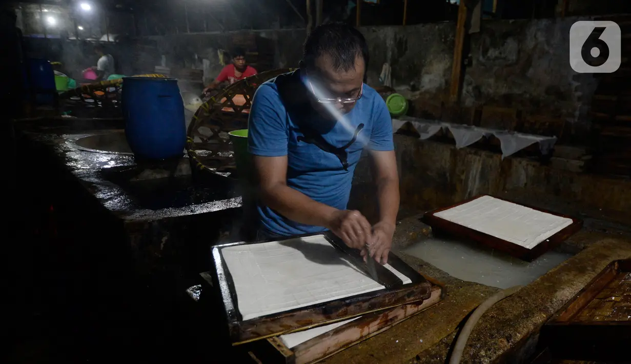 Pekerja memotong tahu di salah satu industri tahu tradisional , di Babakan Pocis, Setu, Tangerang Selatan, Selasa (14/7/2020). Pesanan tahu yang sempat menurun hingga 50 persen di awal pandemi Covid-19, kini mulai perlahan naik. (merdeka.com/Dwi Narwoko)