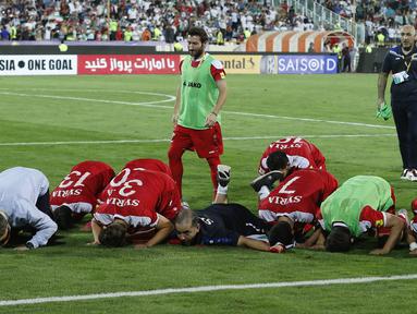Para pemain Suriah sujud usai menahan imbang Iran 2-2 pada laga kualifikasi Piala Dunia 2018 di Stadion Azadi, Taheran, Selasa (5/9/2017). Finis urutan tiga grup A, Suriah lolos ke babak playoff untuk menantang Australia. (AFP/Atta Kenare)